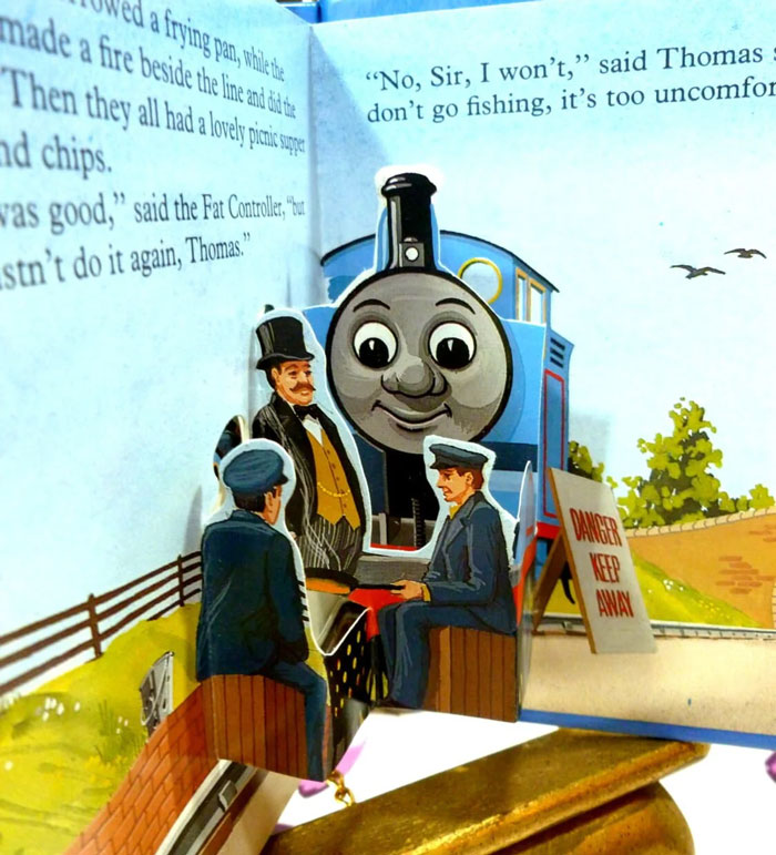 Pop-up book page featuring a train character illustrating glitch in the matrix children's story
