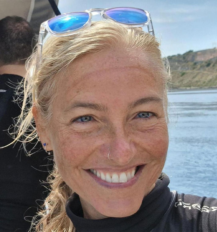 Close-up smiling woman with sunglasses by water on Maldives diving trip
