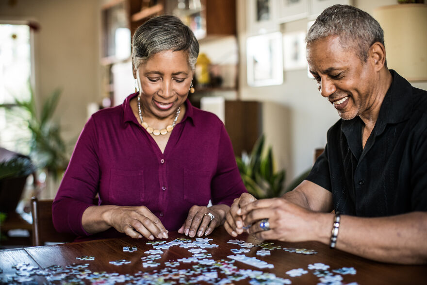 Couple assembling puzzle as a mood booster activity at home