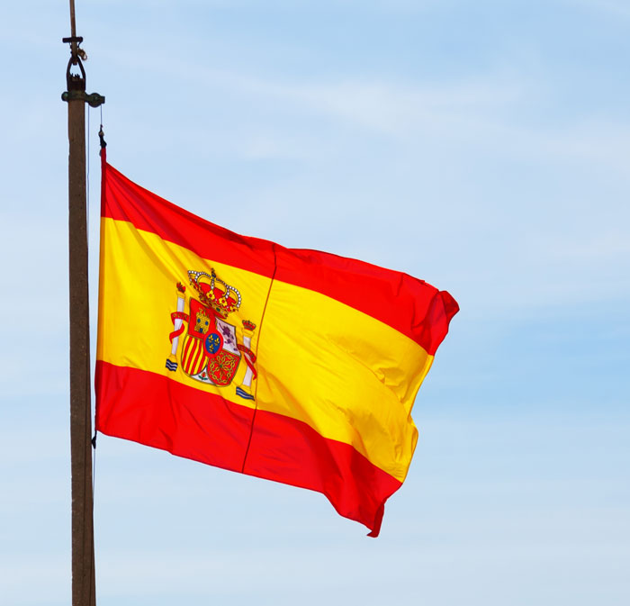 Spanish flag waving in the wind representing European culture to American visitors