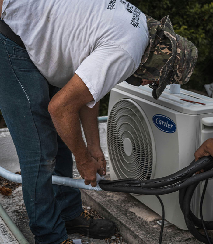 Technician working on Carrier air conditioning unit outdoors
