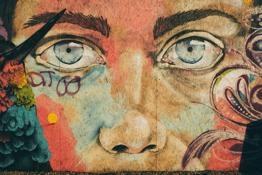 Colorful street art mural of a face expressing emotional happy crying