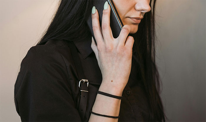 Close-up of a woman talking on phone, symbolizing communication in a restrictive religious community