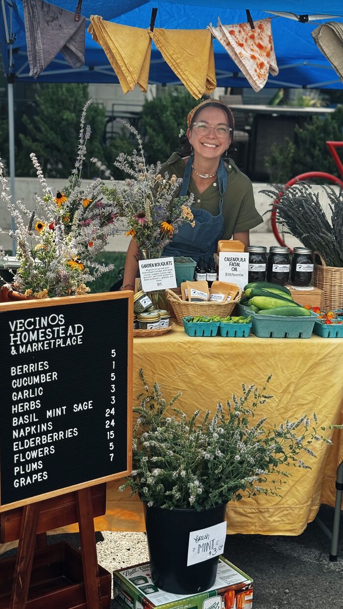 Woman selling fresh herbs and produce at a market stall