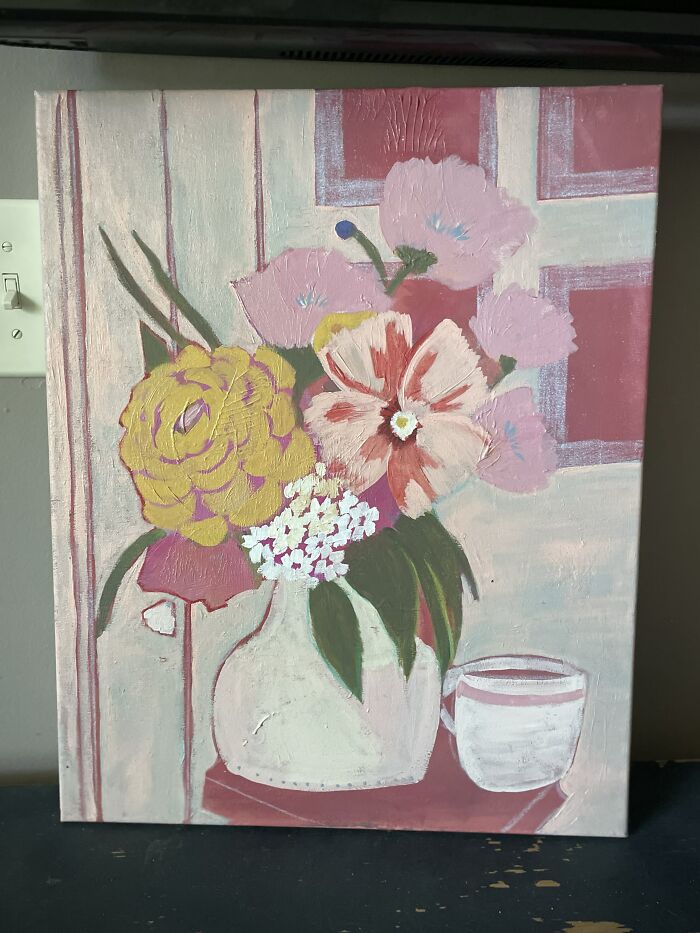 Colorful floral painting on canvas with cup on table