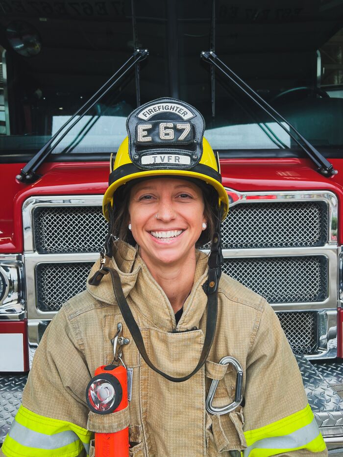 Female firefighter in uniform standing in front of fire truck