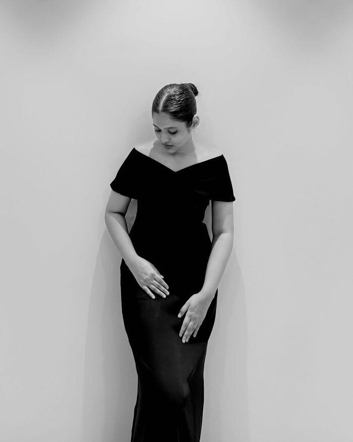 Black and white photo of woman in elegant black dress posing