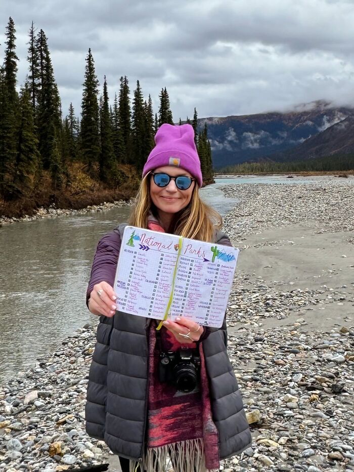 Woman traveler with national parks checklist enjoying nature outdoors