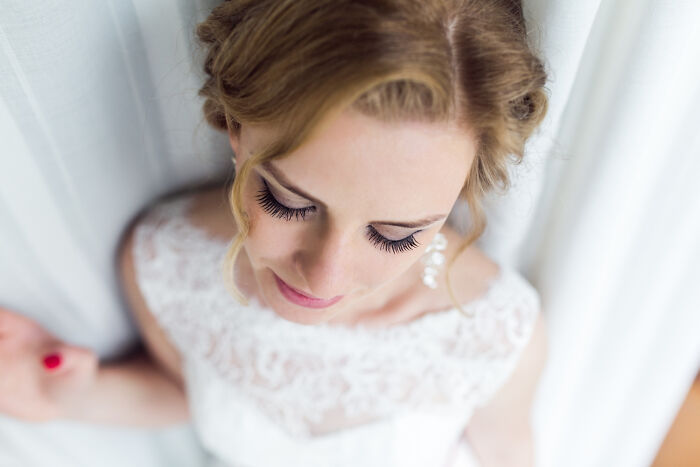 Close up of bride in lace wedding dress with soft makeup at wedding photography session