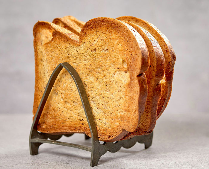 Four slices of perfectly toasted bread in a metal rack. Weirdest packages mailmen deliver are not usually food.