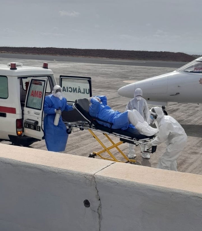 Medical team in PPE transferring a patient on a stretcher to an ambulance, likely during a hantavirus outbreak response.