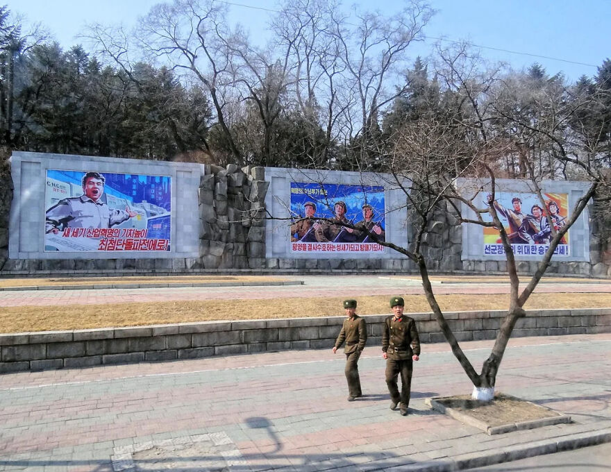 Two soldiers walk past propaganda posters, representing some of the most stressful jobs in the world.
