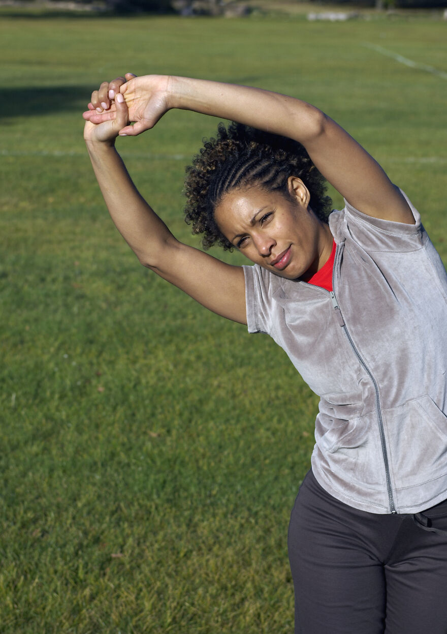 Woman stretching in a park as a mood booster exercise