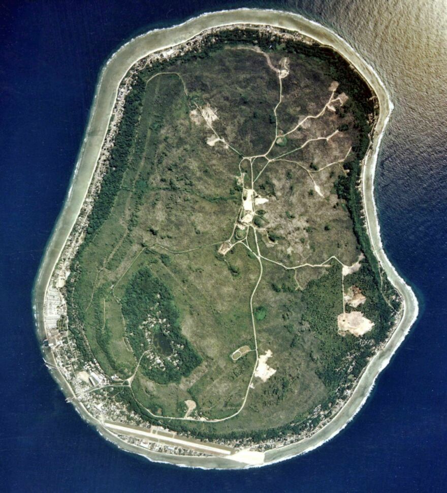Satellite image of a small, round island with visible roads and vegetation