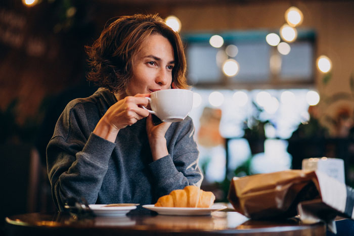 Woman enjoying coffee in European cafe atmosphere