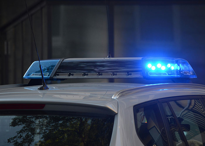 Police car with flashing blue lights, symbolizing investigations into people vanishing