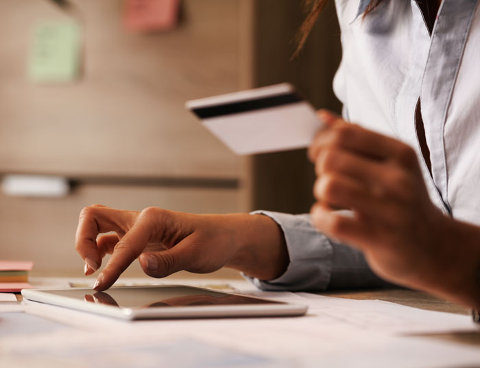 Woman using tablet and credit card to manage online statistics data