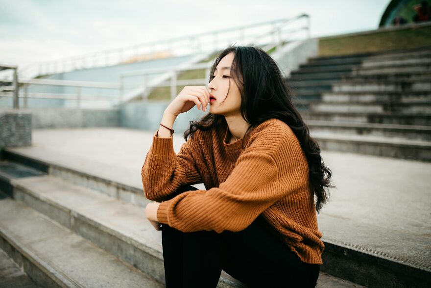 Young woman sitting on steps deep in thought after happy crying