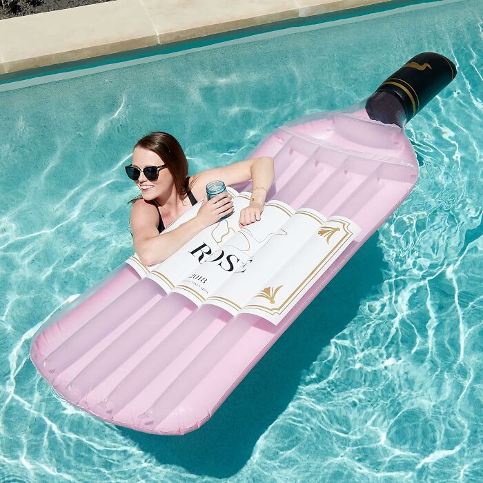 A woman on a rose wine bottle pool float. A humorous gift for Mother's Day, bringing joy and relaxation.