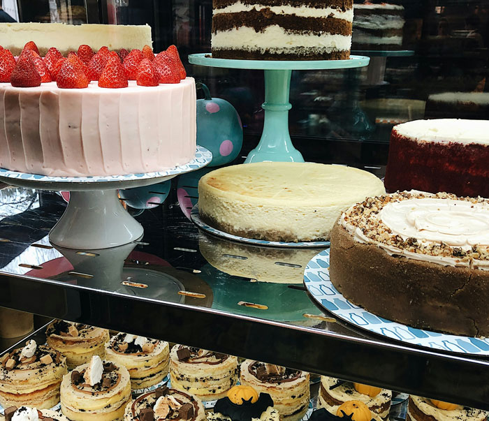 Display of various wedding cakes and desserts in a bakery case Display of various wedding cakes and desserts in a bakery case