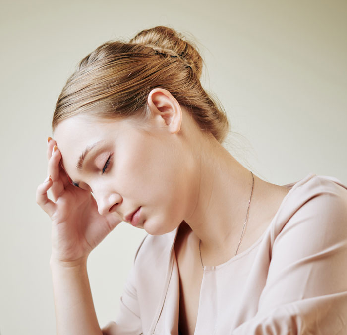 Stressed woman with hand on forehead, related to wedding cake obsession Stressed woman with hand on forehead, related to wedding cake obsession