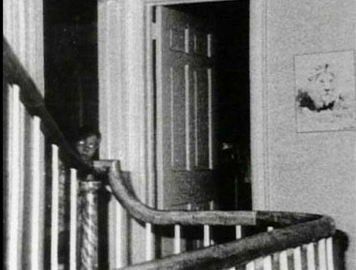 Paranormal photo with a ghostly figure appearing behind a staircase railing