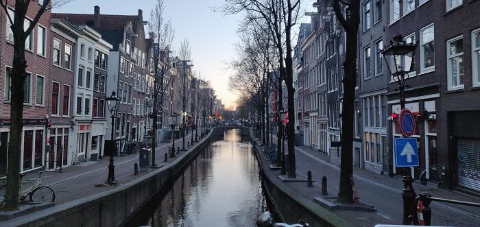 City canal at dusk flanked by historic buildings in rare urban moment