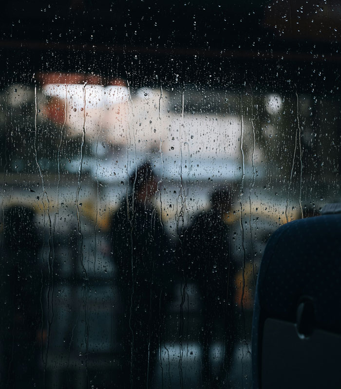 Raindrops on window with silhouette of people symbolizing PR fail mood
