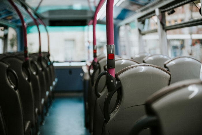 Empty seats and handles inside a European public bus interior