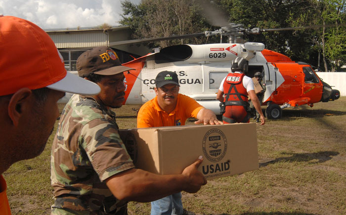 Volunteers unloading USAID aid box near rescue helicopter statistics