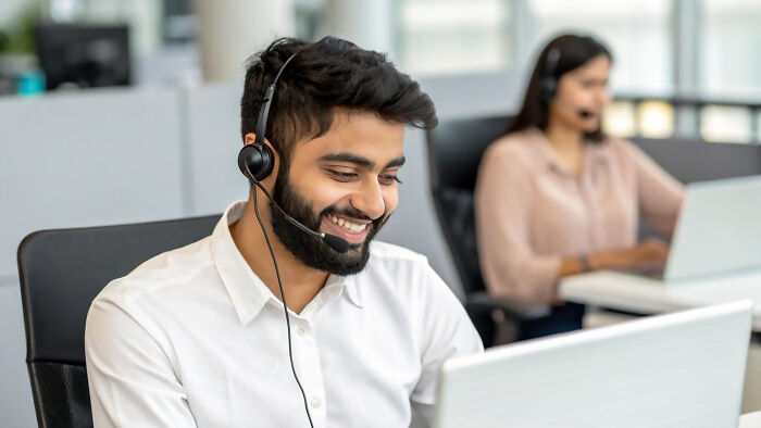 Customer service representative talking on headset in call center
