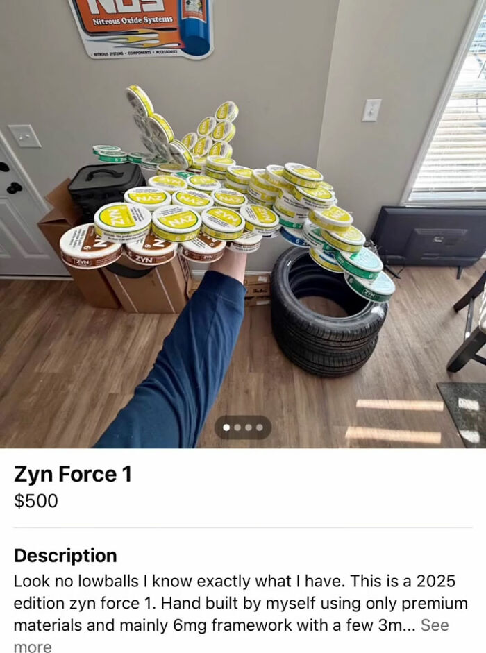 Hand holding a large collection of Zyn Force 1 snus cans in a room for sale