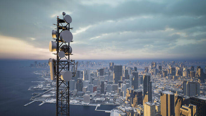 Telecommunication tower overlooking city skyline