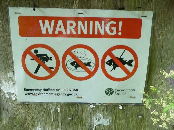 Warning sign forbidding fishing and feeding fish in UK environment area