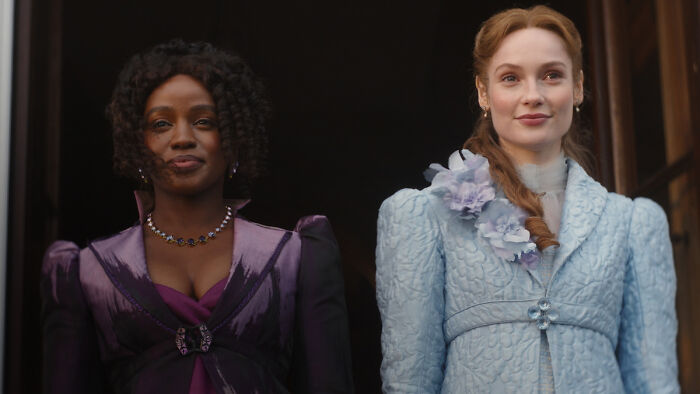 Two Bridgerton women dressed in period costumes smiling Two Bridgerton women dressed in period costumes smiling