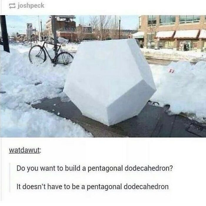 A perfectly shaped pentagonal dodecahedron snow sculpture on a sidewalk, next to a bicycle covered in snow. Funny math meme.
