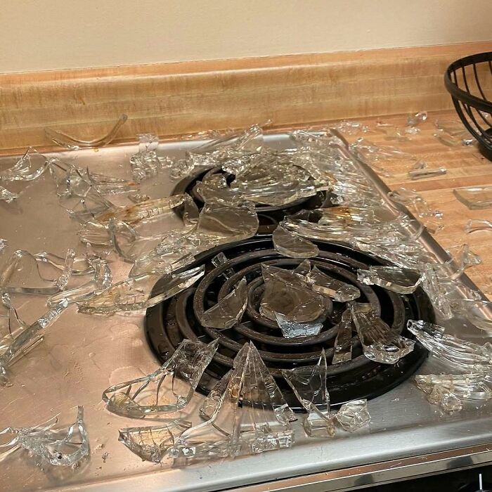 Broken glass stove top with shattered pieces scattered on burner