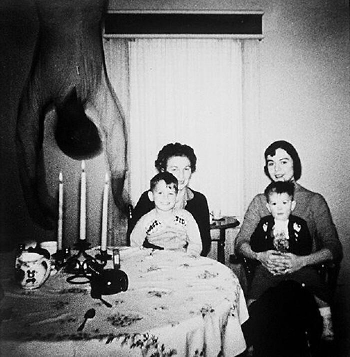 Black and white family photo with upside-down figure on the left