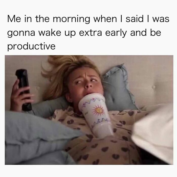Woman in bed with a drink and phone, struggling to be productive early. A random meme bringing laughter.