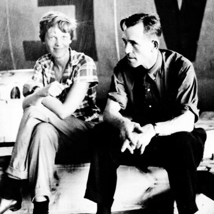 Historical black and white photo of two people sitting and talking, representing fascinating history facts