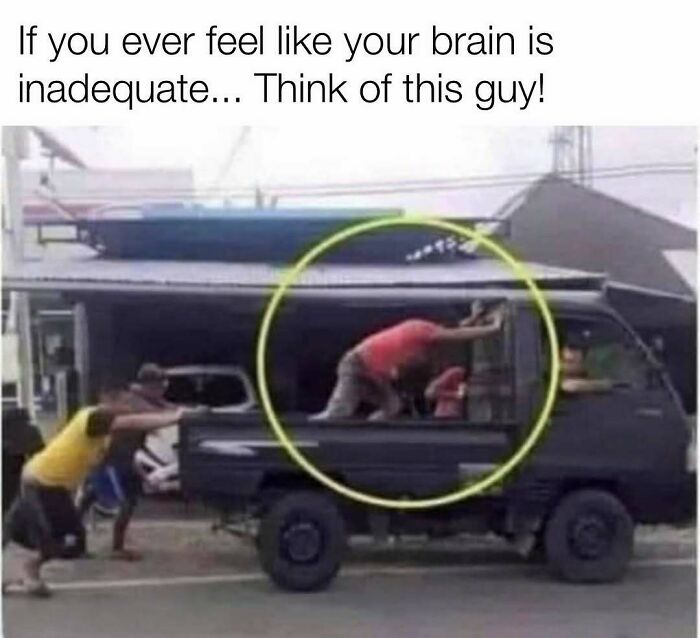 Man pushing a small truck while inside it crouching in a funny setup
