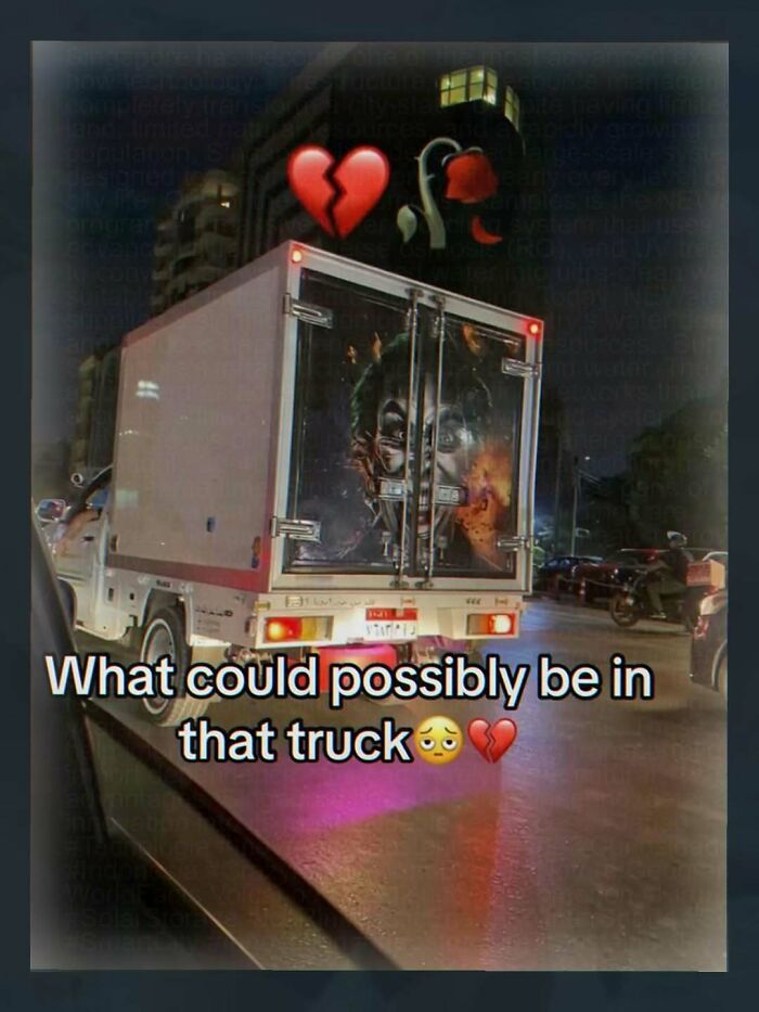 Back of a truck with eerie Joker face illustration at night, random weird image