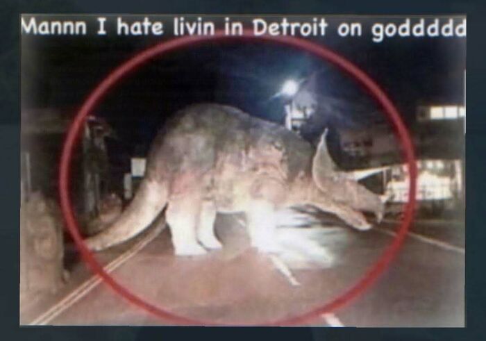 Nighttime image of triceratops dinosaur crossing street with caption about living in Detroit
