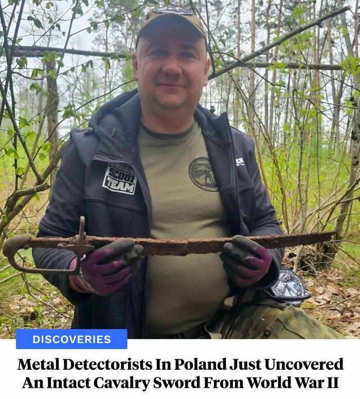 Metal detectorist in Poland holding intact World War II cavalry sword found in forest