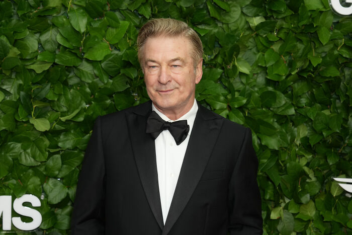 Alec Baldwin in tuxedo at a green event backdrop, linked to reactions on The Odyssey casting