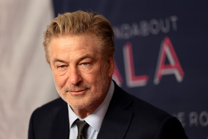 Alec Baldwin in a suit at an event, facing backlash linked to The Odyssey casting response