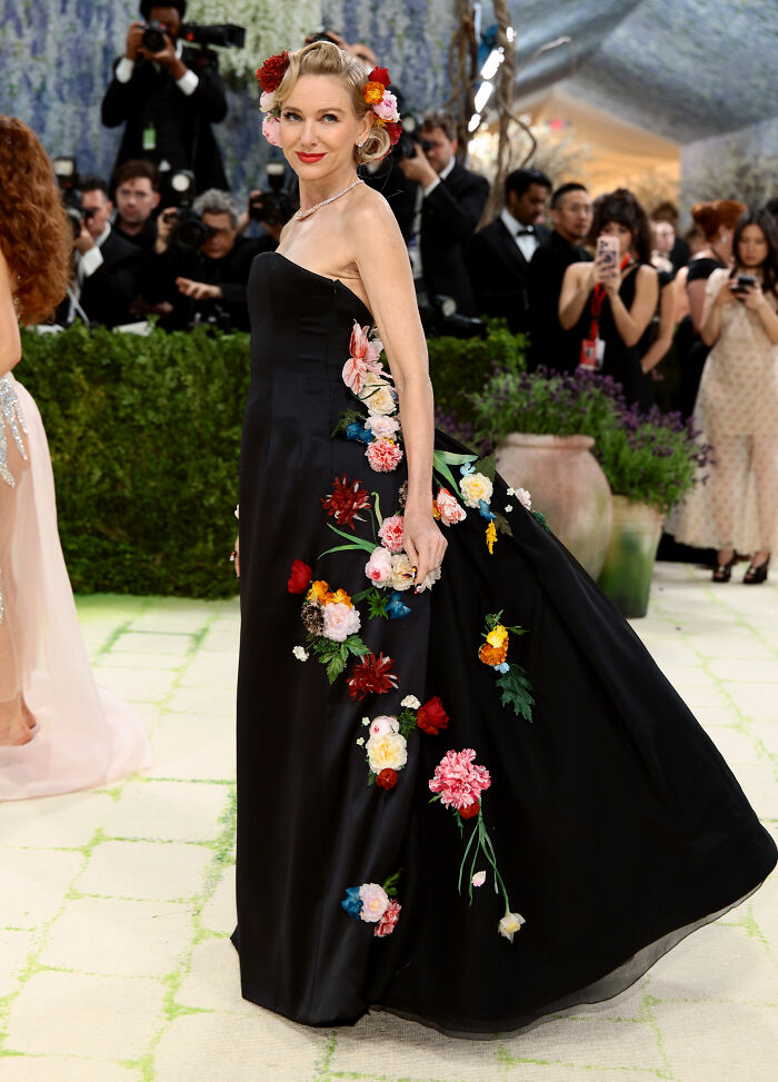 Naomi Watts in a black strapless gown with vibrant floral appliqués at the MET Gala. One of the most jaw-dropping outfits.