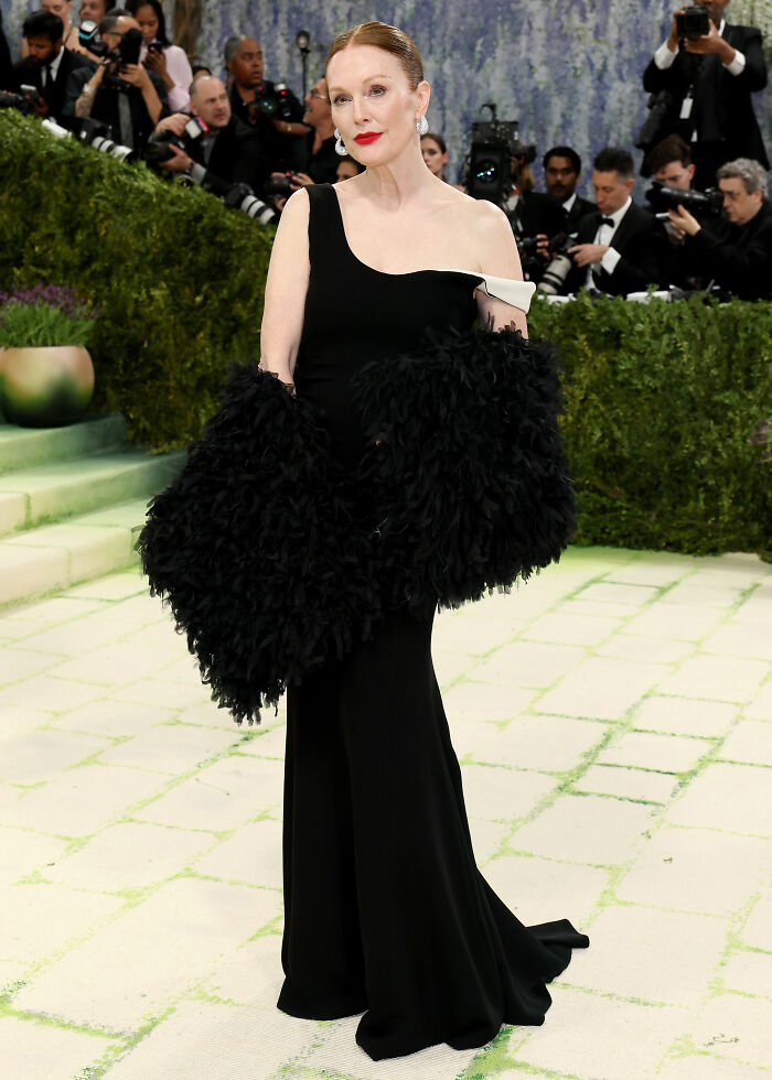 Julianne Moore in a jaw-dropping outfit at the 2026 MET Gala, wearing a black gown and feathered sleeves.