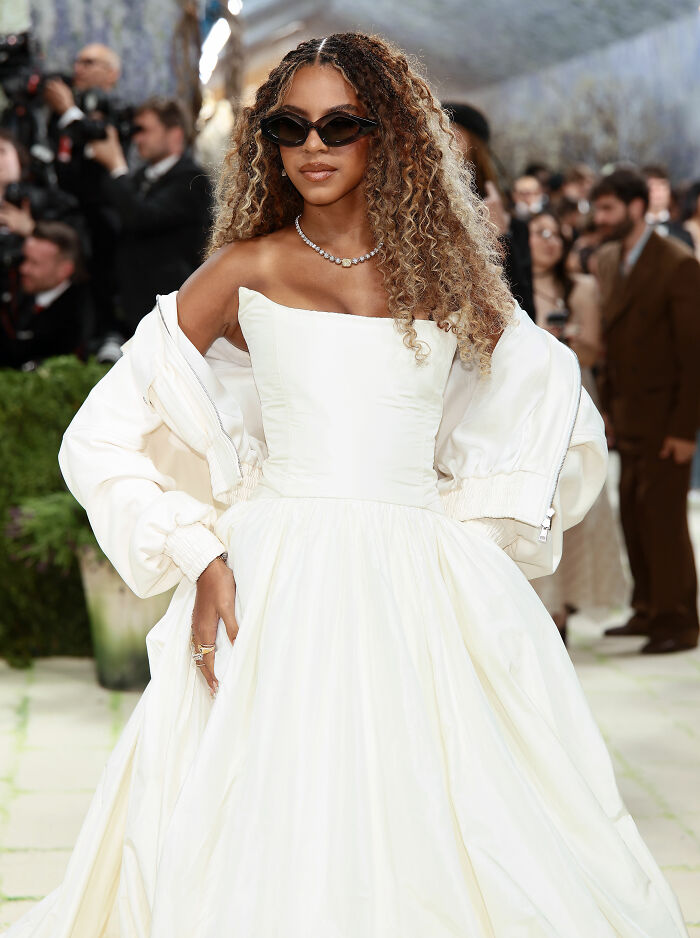 Beyoncé in a jaw-dropping outfit, a long white gown and sunglasses, at the 2026 MET Gala.