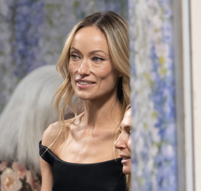 Olivia Wilde no Met Gala, com cabelos loiros e um vestido preto com ombros largos, despertando a preocupação dos fãs com as comparações com Gollum.